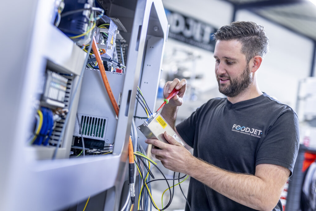 FoodJet technician wiring a control cabinet in the assembly hall